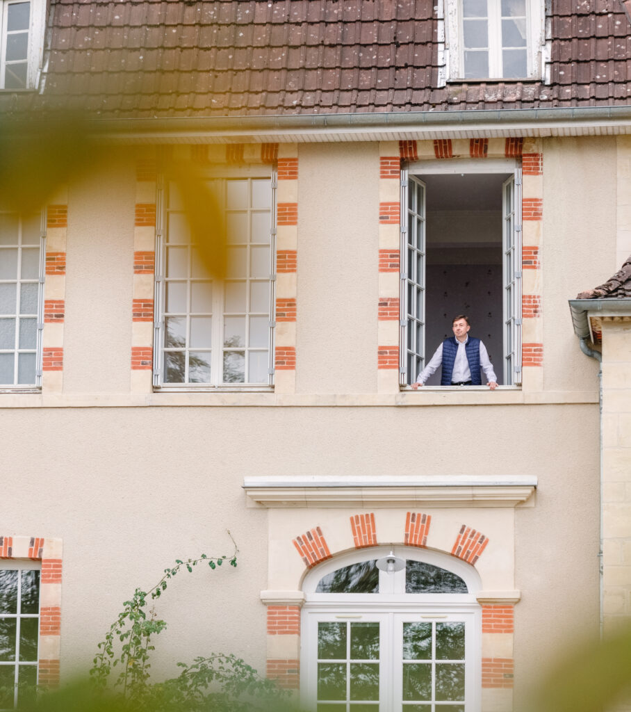 Georges Lheureux à une fenêtre du manoir Montflambert